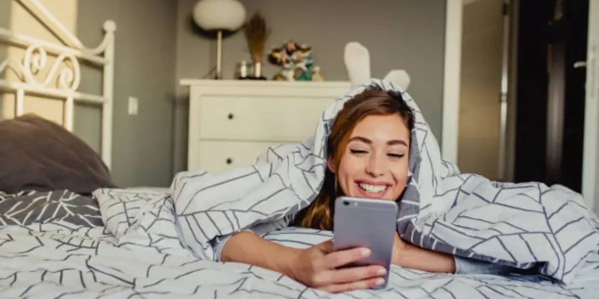 Mujer feliz y relajada en su cama gracias a los beneficios del agua ozonizada con Ozonify en su hogar