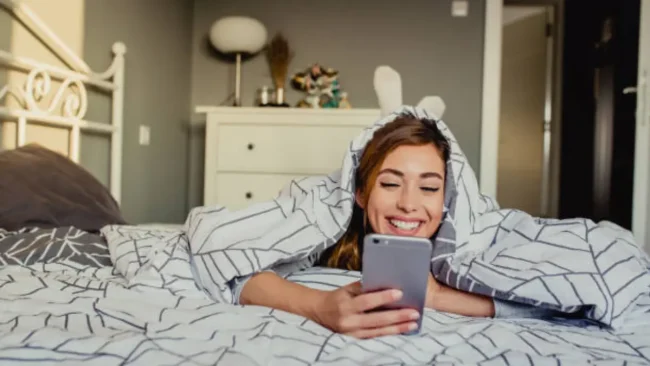 Mujer feliz y relajada en su cama gracias a los beneficios del agua ozonizada con Ozonify en su hogar