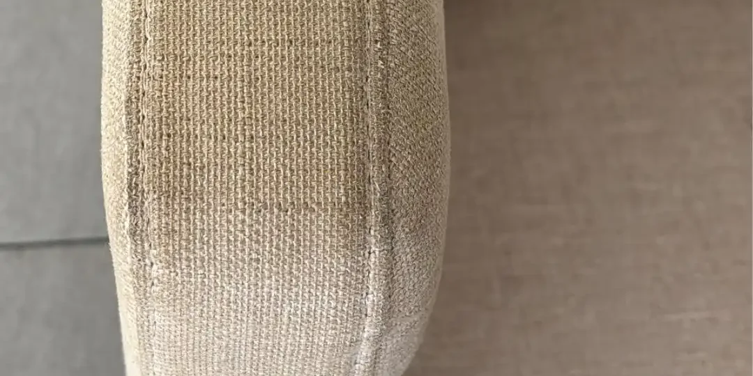 Sillón de tela con manchas por uso diario en apoyabrazos