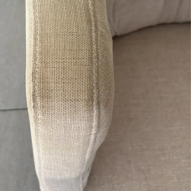 Sillón de tela con manchas por uso diario en apoyabrazos