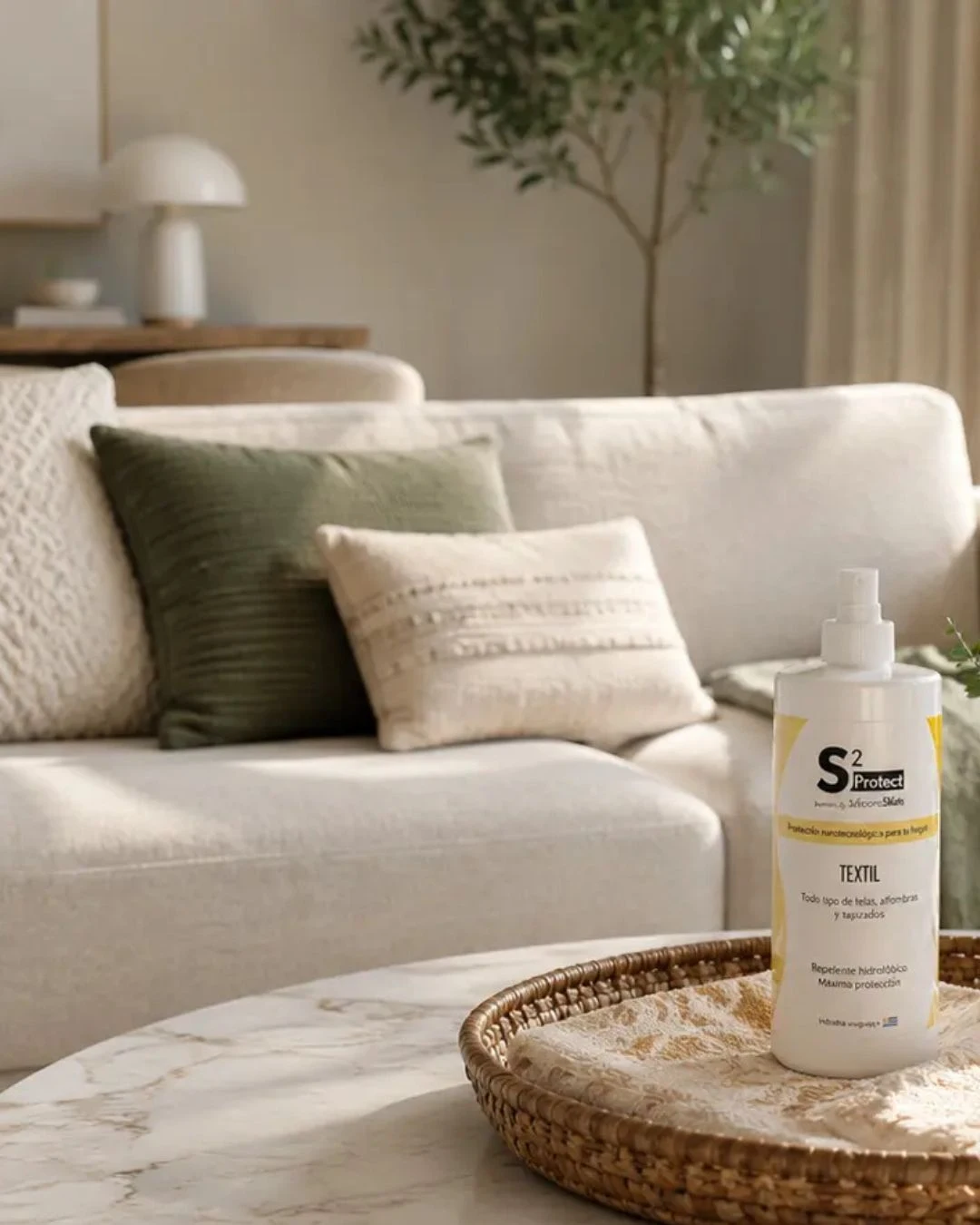 Producto SecondSkin para protección de textiles en un living con sillón claro